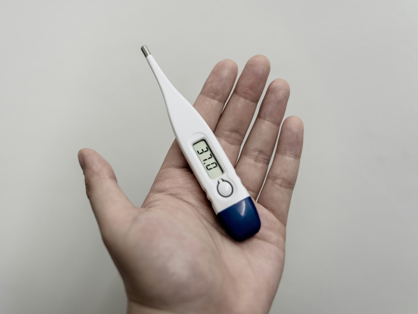 Termómetro digital na mão a mostrar a temperatura