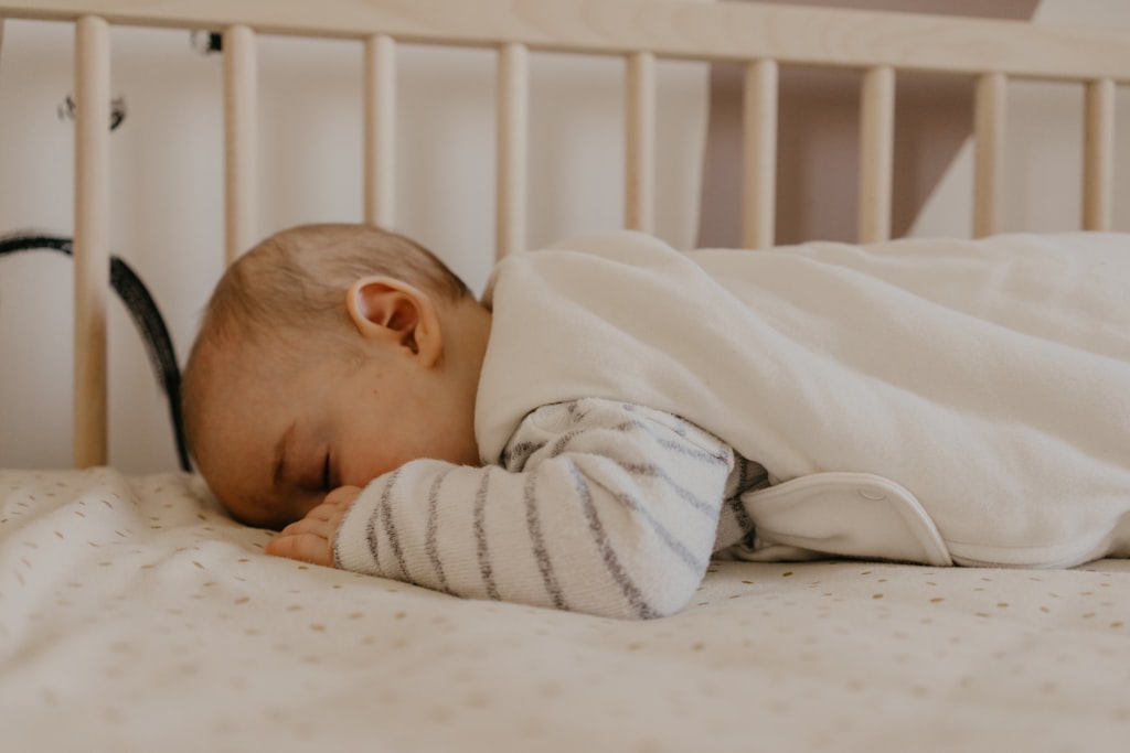 Bebé a dormir no berço, vigiado à distância