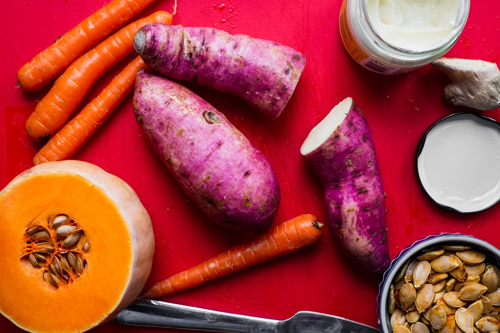 Cenoura, batata-doce e abóbora numa tábua, ingredientes para papas de bebé